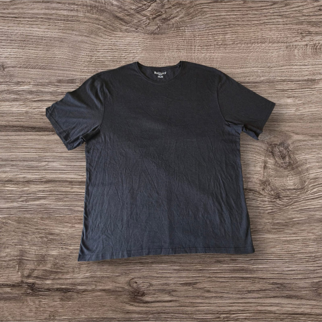 T-shirt nera a maniche corte Ottoman Kumus Bexleys MAN in cotone morbido con girocollo su sfondo in legno