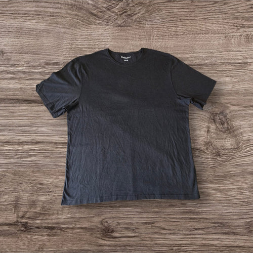 T-shirt nera a maniche corte Ottoman Kumus Bexleys MAN in cotone morbido con girocollo su sfondo in legno