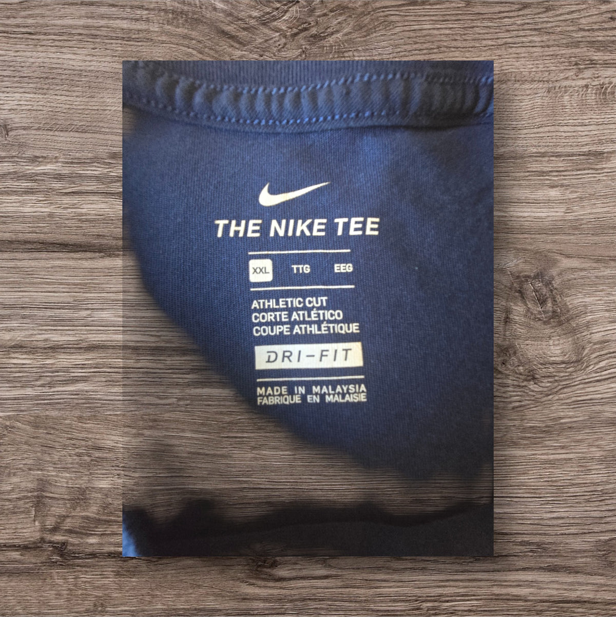 Etichetta interna di una maglietta sportiva Ottoman Kumus Nike blu navy con tecnologia Dri-FIT e taglio atletico