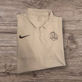 Polo tecnica bianca Ottoman Kumus Nike Dri-FIT con logo e stemma Olympic F.C. su sfondo in legno