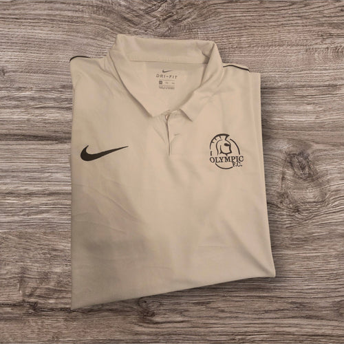 Polo tecnica bianca Ottoman Kumus Nike Dri-FIT con logo e stemma Olympic F.C. su sfondo in legno