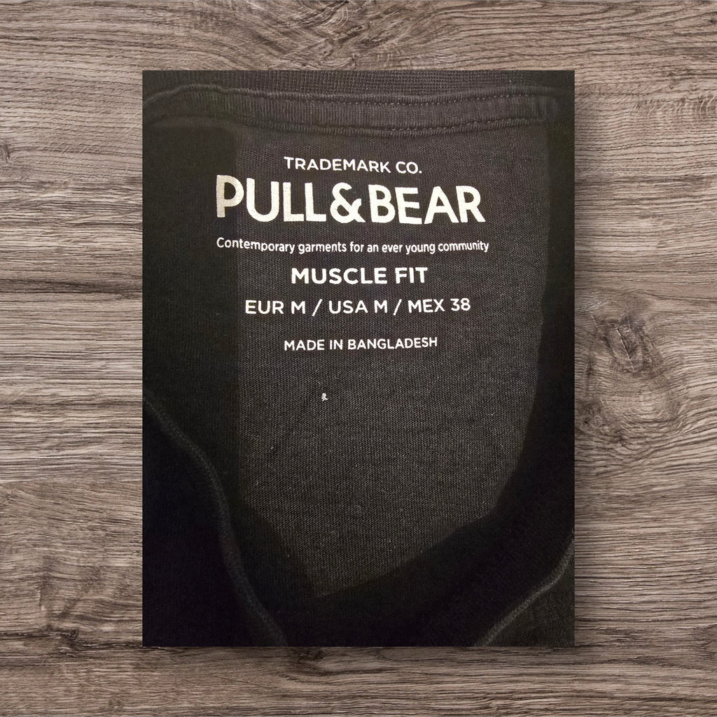 Etichetta interna di una t-shirt nera Ottoman Kumus Pull&Bear con vestibilità muscle fit taglia M