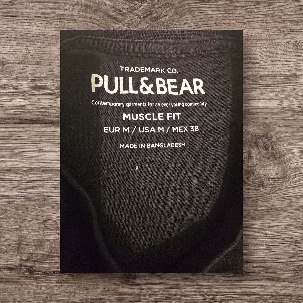 Etichetta interna di una t-shirt nera Ottoman Kumus Pull&Bear con vestibilità muscle fit taglia M