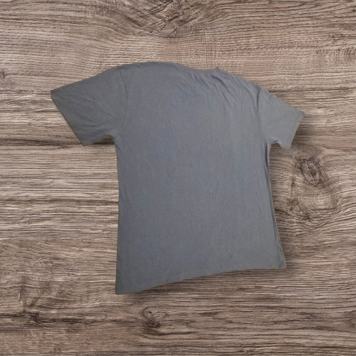 T-shirt Mavi grigio-azzurra in cotone a maniche corte, vista posteriore, su sfondo in legno, Ottoman Kumus