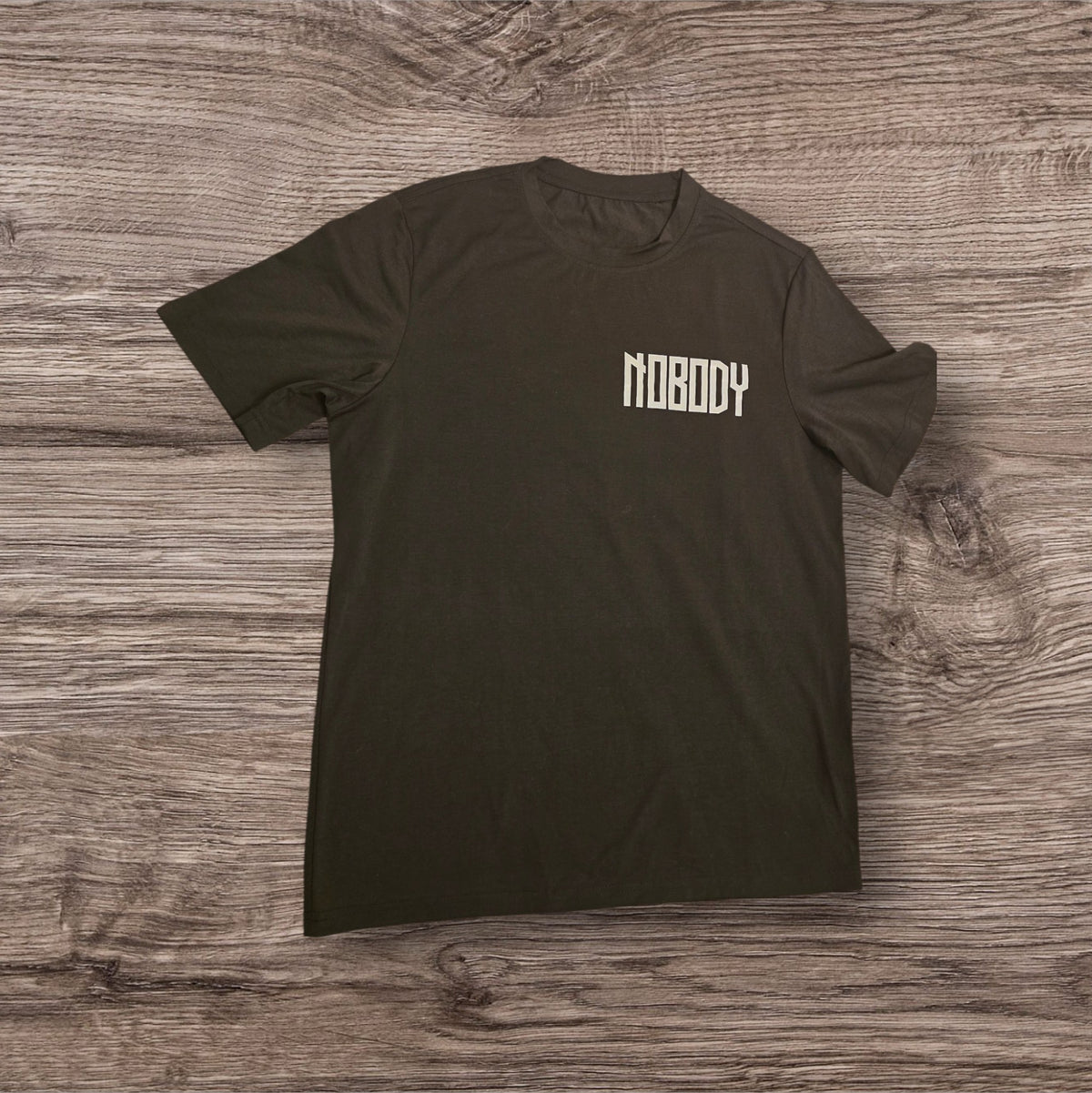 T-shirt nera Ottoman Kumus in cotone con scritta Nobody stampata sul petto, stile streetwear minimalista.