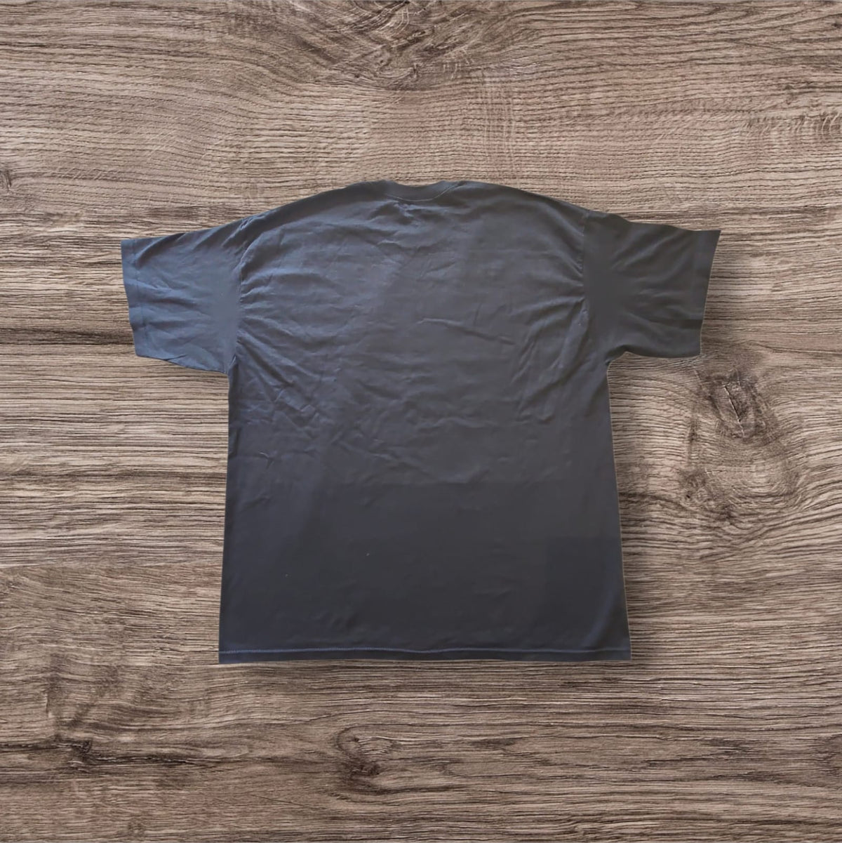 Retro della t-shirt nera in cotone Ottoman Kumus a maniche corte su sfondo in legno