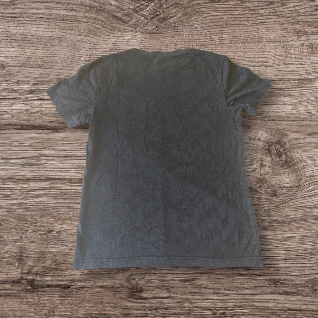 T-shirt nera in cotone Ottoman Kumus vista posteriore su sfondo in legno
