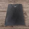 T-shirt nera a maniche corte Ottoman Kumus Bexleys Man in cotone morbido con scollo rotondo su sfondo in legno